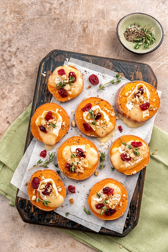 Baked Sweet Potato Rounds topped with brie cheese, cranberry and Walnut. Thanksgiving appetizer bites.