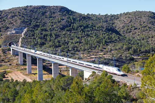 Roda de Bera, Spain - February 20, 2022: Talgo 350 high-speed train of RENFE on the Madrid - Barcelona high speed rail railway line near Roda de Bera in Spain.