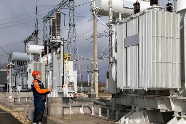 A power engineer inspects substation equipment. Energy. Industry