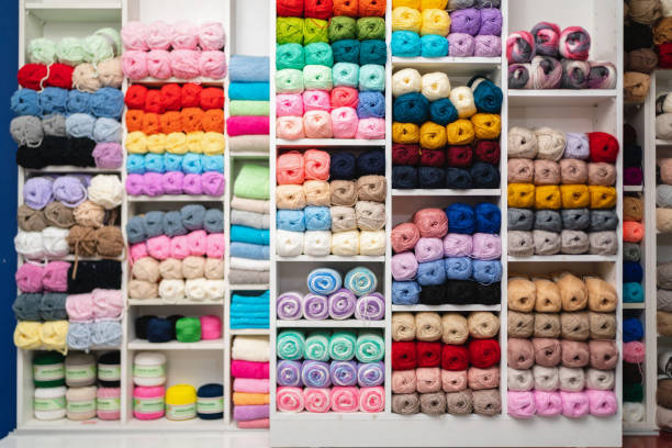 Wall with balls of wool in different color on the shelf stock photo