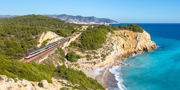 Sitges, Spain - February 20, 2022: Civia regional train operated by RENFE Rodalies de Catalunya near Sitges in Spain.