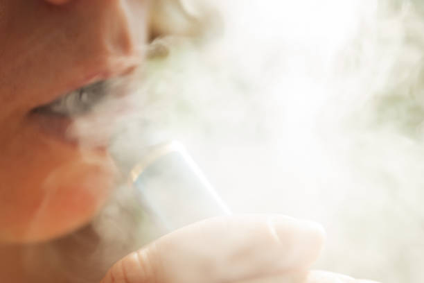 woman smokes vape, electronic cigarette smoke, addiction, bad habits stock photo