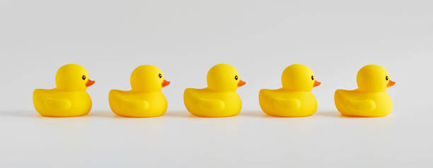 istock Yellow rubber ducks arranged in a row on white background 1388134452