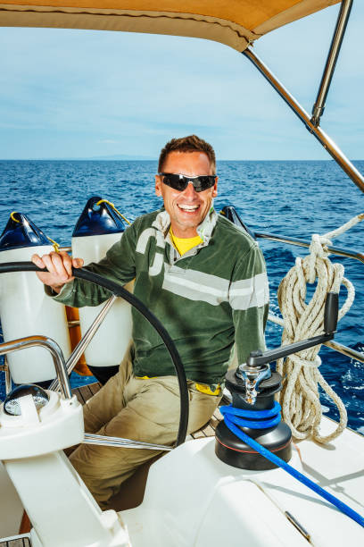istock Happy skipper on sailboat 1388136403