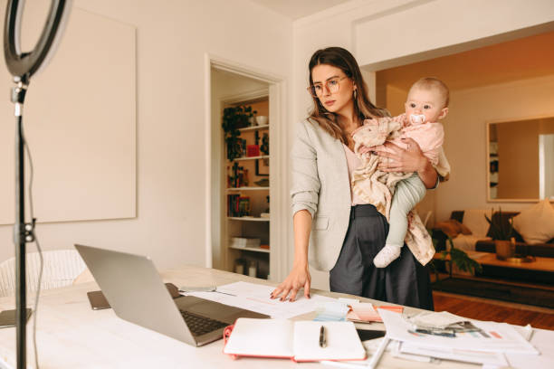 istock Interior designer holding her baby while working in her home office 1388137952