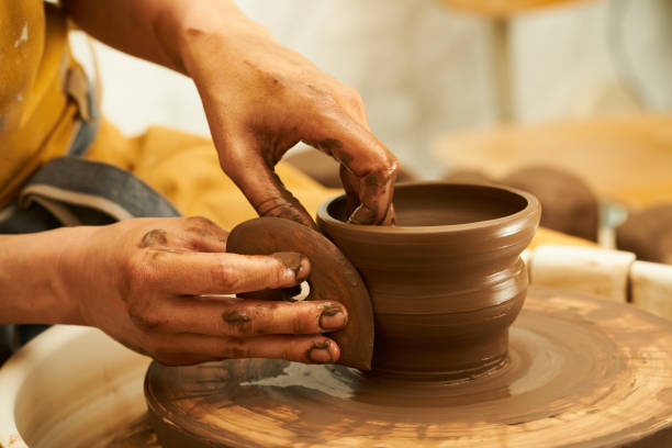 istock A Potter works with red clay on a Potter's wheel in the workshop.