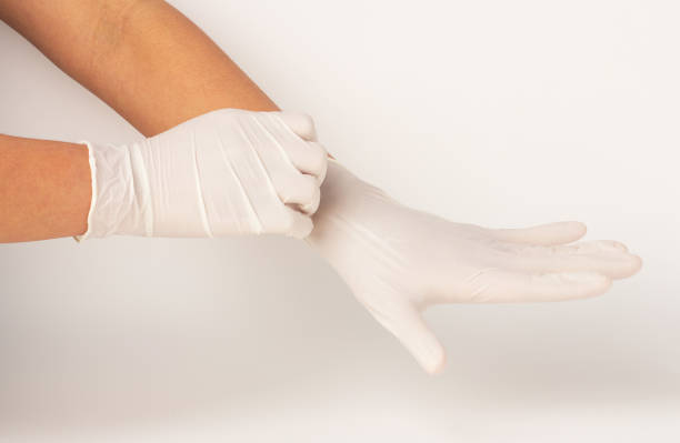 istock Hands are wearing white rubber gloves and pulling isolated on white background. 1388138609