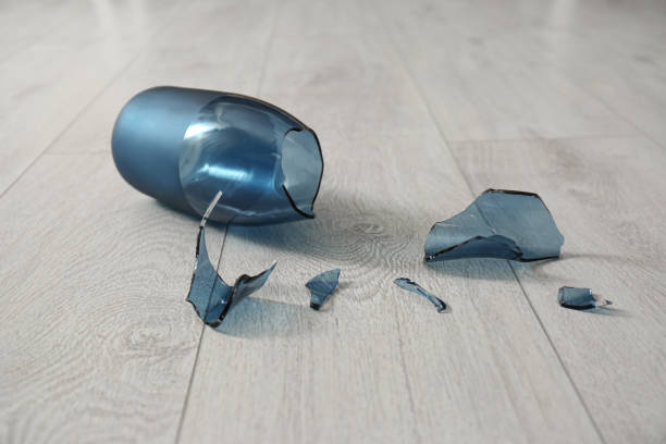 istock Broken blue glass vase on wooden floor, closeup 1388140220