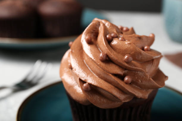istock Delicious cupcake decorated with cream on plate, closeup view 1388140378