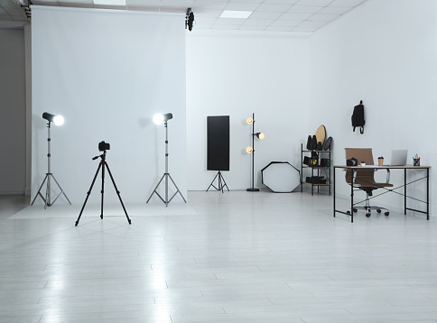 Photo studio interior with set of professional equipment and workplace