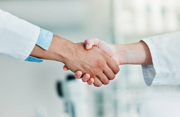istock Closeups shot of two unrecognisable scientists shaking hands in a lab 1388140484