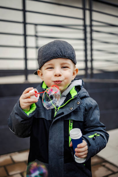 istock A playful little boy blowing bubbles outside. 1388140667