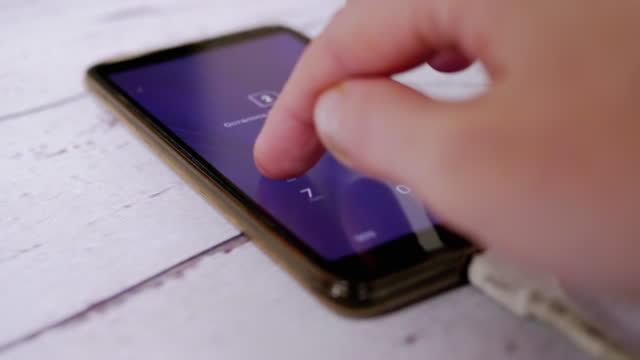 Female Enters a Digital PIN Code on Screen of a Smartphone to Unlock a SIM Card