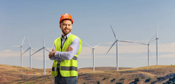 istock Male engineer with a safety vest standing on a wind farm 1388142429