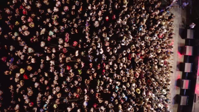 Top view of large crowd of people at a music festival at summer drone footage