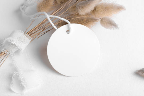 istock Round white tag mockup on a white background with cotton string and boho decoration, dry plants, close up 1388146763