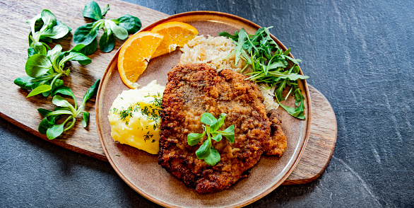 Pork breaded cutlet coated with breadcrumbs with mashed potatoes and cabbage