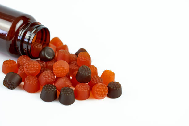 흰색 배경에 베리 맛을 클로즈업한 아기 비타민 - capsule vitamin pill red orange 뉴스 사진 이미지