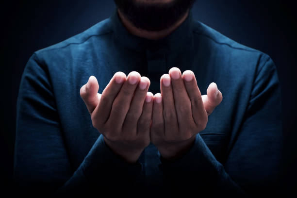 istock Muslim man praying on dark background 1388151814