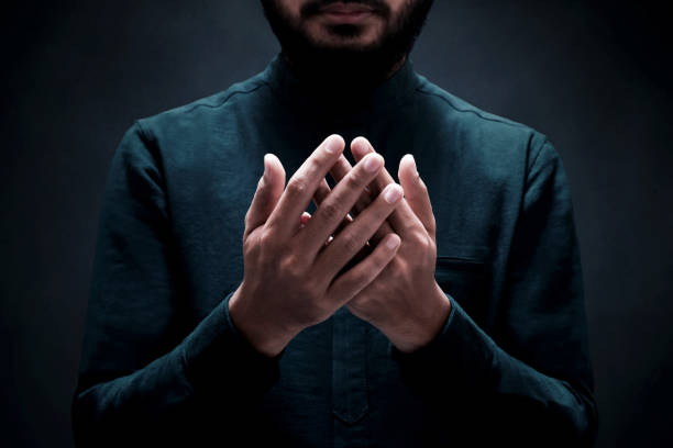 istock Muslim man praying on dark background 1388151824