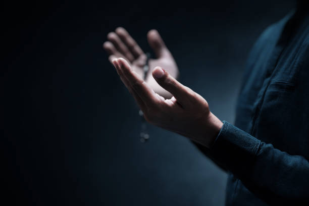 istock Muslim man praying on dark background 1388152481