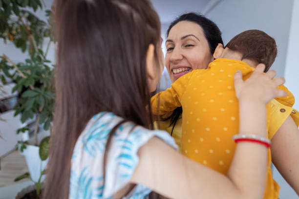 istock Happy mother hugging kids 1388152795
