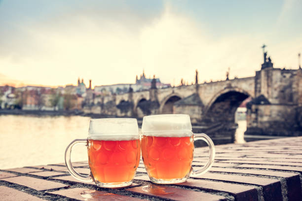bier in prag, tschechien mit blick auf die karlsbrücke - tschechische republik stock-fotos und bilder