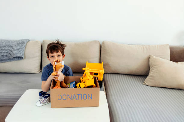 istock Boy donates his toys packed in a cardboard box. 1388154149