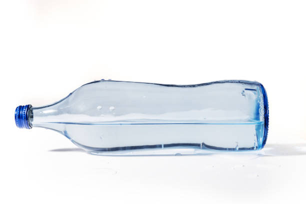 istock Glass water bottle lying down and isolated on white background. 1388158688