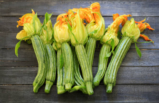 Zucchini with flowers. Fresh zucchini with flowers on a wooden table. Directly above. squash vegetable stock pictures, royalty-free photos & images