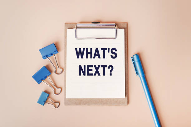 istock What's Next - words written in a notebook. Question for Social media, Blog post. Top view image of notebook and with many paper clips and blue pen on beige background 1388159443