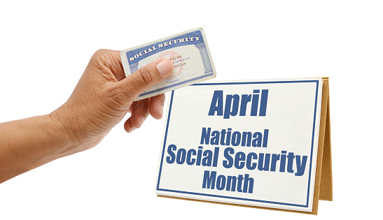 Hand holding Social Security Card in front of National Social Security Month on white background