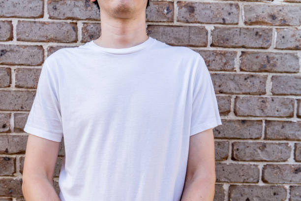 istock Man wearing mockup white t-shirt on brick wall background. Template copy space 1388161676
