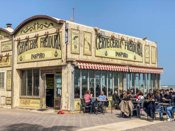 Valencia, Spain - March 27, 2022:  People enjoying the afternoon in bar next to the beach. There are many food establishments along the city coast where people go to relax and enjoy the sun, specially during the weekends
