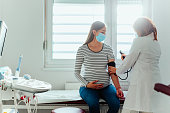 Pregnant woman having examination at doctor office during pandemic