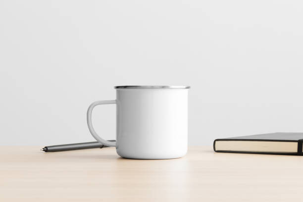 istock Enamel mug mockup with workspace accessories on the wooden table. 1388165821