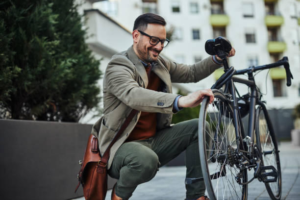 istock Businessman checking tire pressure before going to work by bike 1388166238