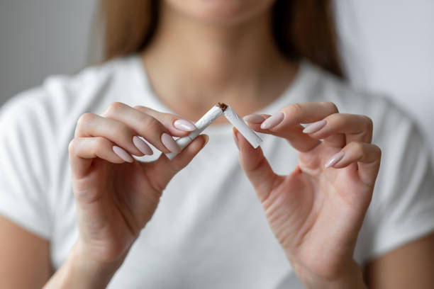 woman quitting smoking breaks last cigarette - quitting imagens e fotografias de stock