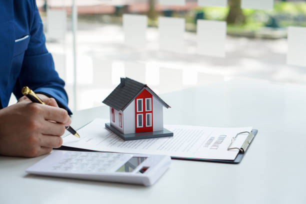 istock Real estate office home sales agents work with contract documents with house designs and calculators on the table. 1388167084