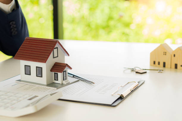 istock Real estate office home sales agents work with contract documents with house designs and calculators on the table. 1388167192