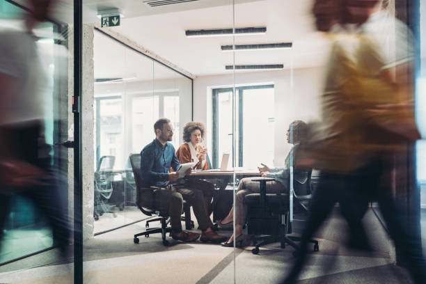 istock Focus on a small group of business persons talking inside a glass room 1388167576