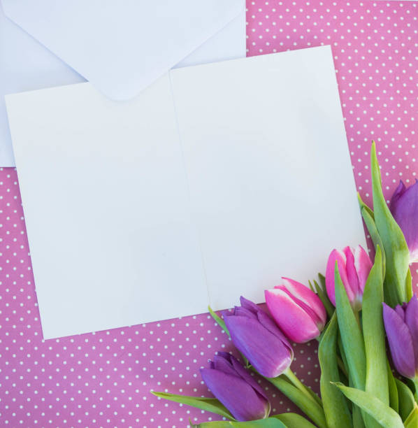 istock white card and envelope on pink dotted ground with tulips with space for text 1388168462
