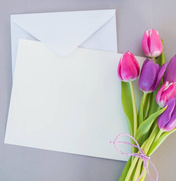istock white card and envelope on grey ground with tulips with space for text 1388168653