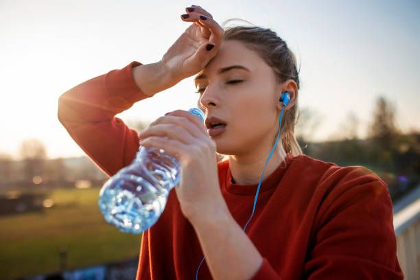 istock Woman hydrating after jogging on a hot day 1388169979