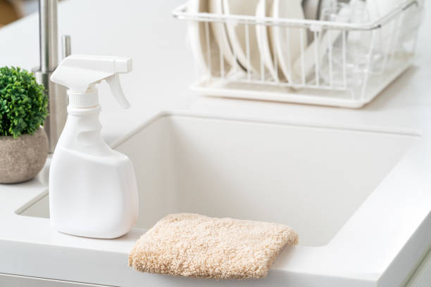 istock Cleaning product spray bottle in modern kitchen beside sink. 1388171996