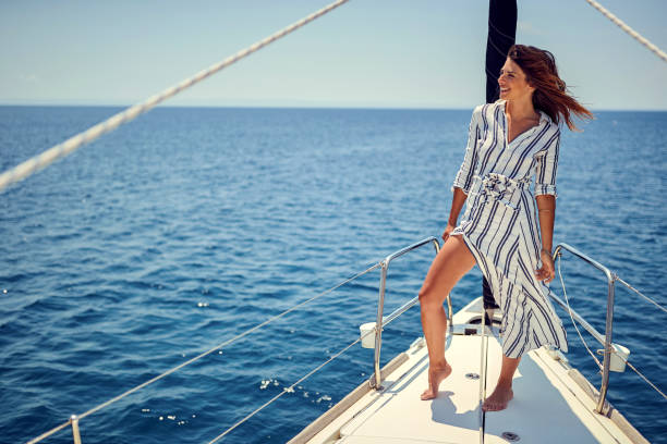 istock A young handsome female model is posing for a photo and enjoying a view while riding on a yacht on the sea. Summer, sea, vacation 1388175138