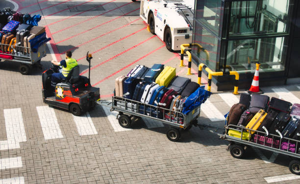 2019年8月4日 - イギリス、ロンドン:空港滑走路で荷物を運ぶ電動手荷物カート - luggage cart ストックフォトと画像