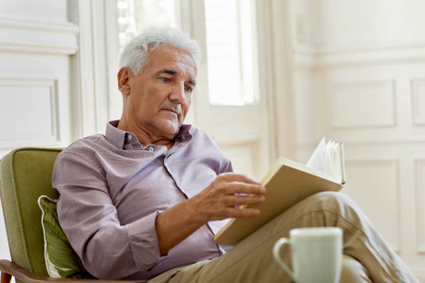 istock Senior man reading book at home during lockdown 1388175922