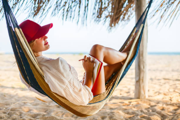 istock Woman writing something in her red planner lying in a hammock 1388177050