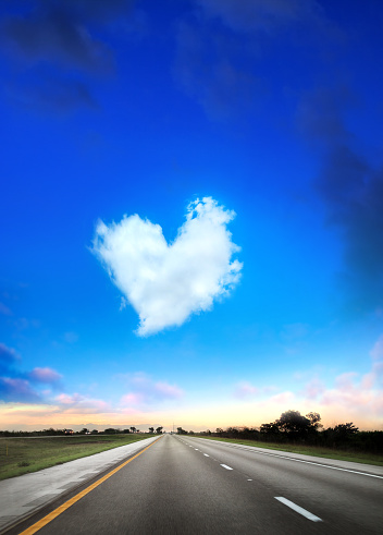 Conceptual image of heart shaped cloud and empty highway